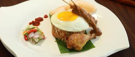 A plate of food with a fried egg, meat, and vegetables.