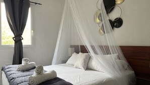 A neatly made bed with white linens, a grey quilt, and a canopy. - Mont Bouquet Lodge (Brouzet-les-Ales)