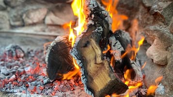 A close-up of a fire with burning wood and glowing embers.