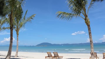 Playa privada, arena blanca, sillas reclinables de playa, sombrillas