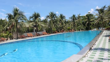 Alberca al aire libre, sombrillas en la alberca y camastros