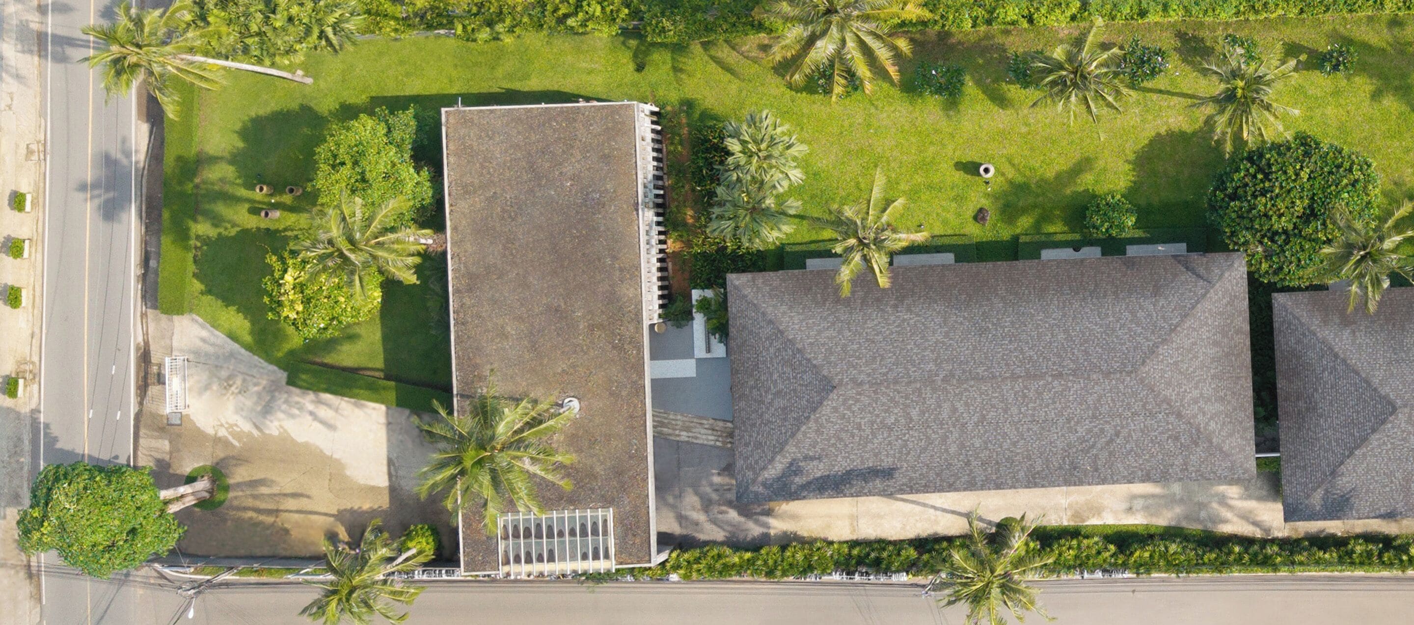An aerial view of a building with a tall, rectangular structure and a flat-roofed section.
