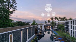 A modern hotel with a pool area, outdoor seating, and a view of the ocean. - AWA Koh Chang (Ko Chang)