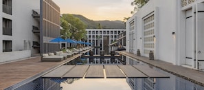 A modern hotel with a pool, lounge chairs, and a wooden deck. - AWA Koh Chang (Ko Chang)
