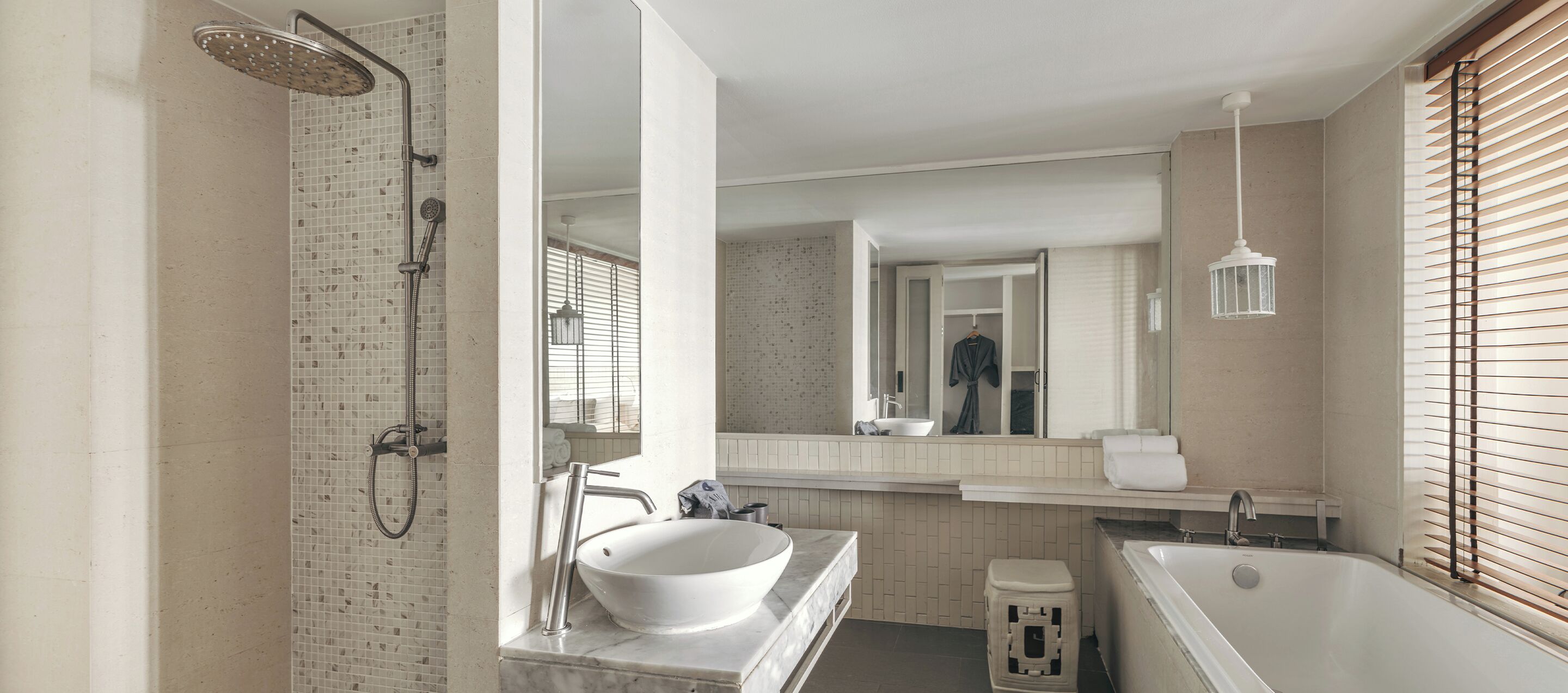 A modern bathroom with a freestanding bathtub, a large mirror, and a shower with a rain showerhead.