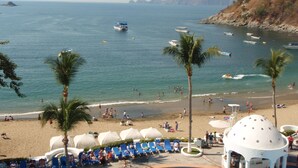 A beach with umbrellas, lounge chairs, and a view of the sea. - Sierra Mar Mazanillo (Manzanillo)