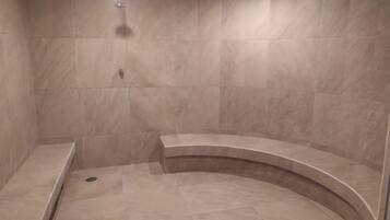 Enjoy a refreshing shower in a, well-lit space with a curved bench.