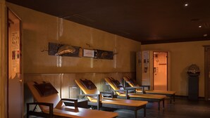 A spa area with multiple massage chairs, wooden tables, and a reception desk. - Hotel Seespitz (Ischgl)
