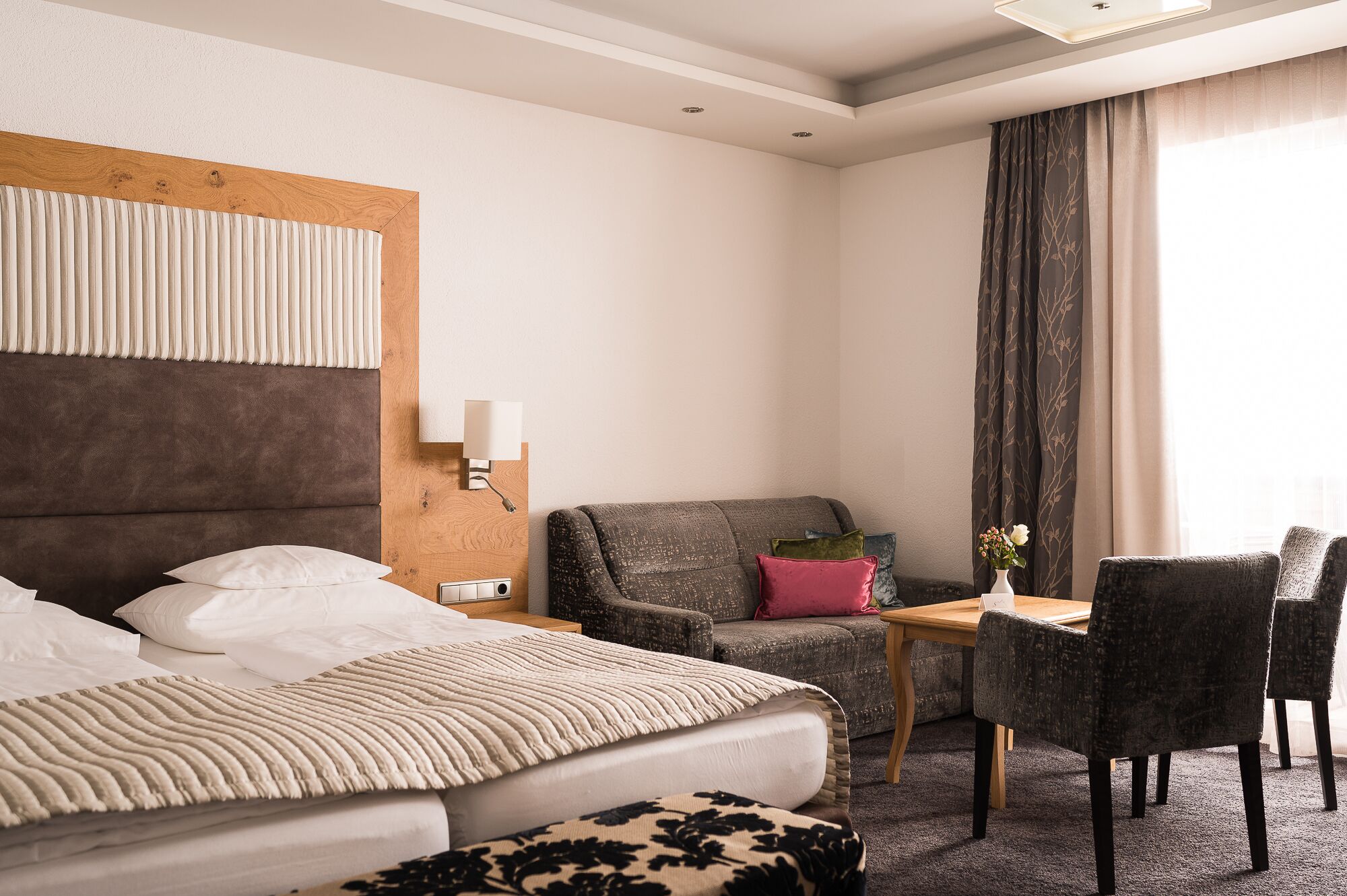 Et hotelværelse med seng, skrivebord, stol og sofa.