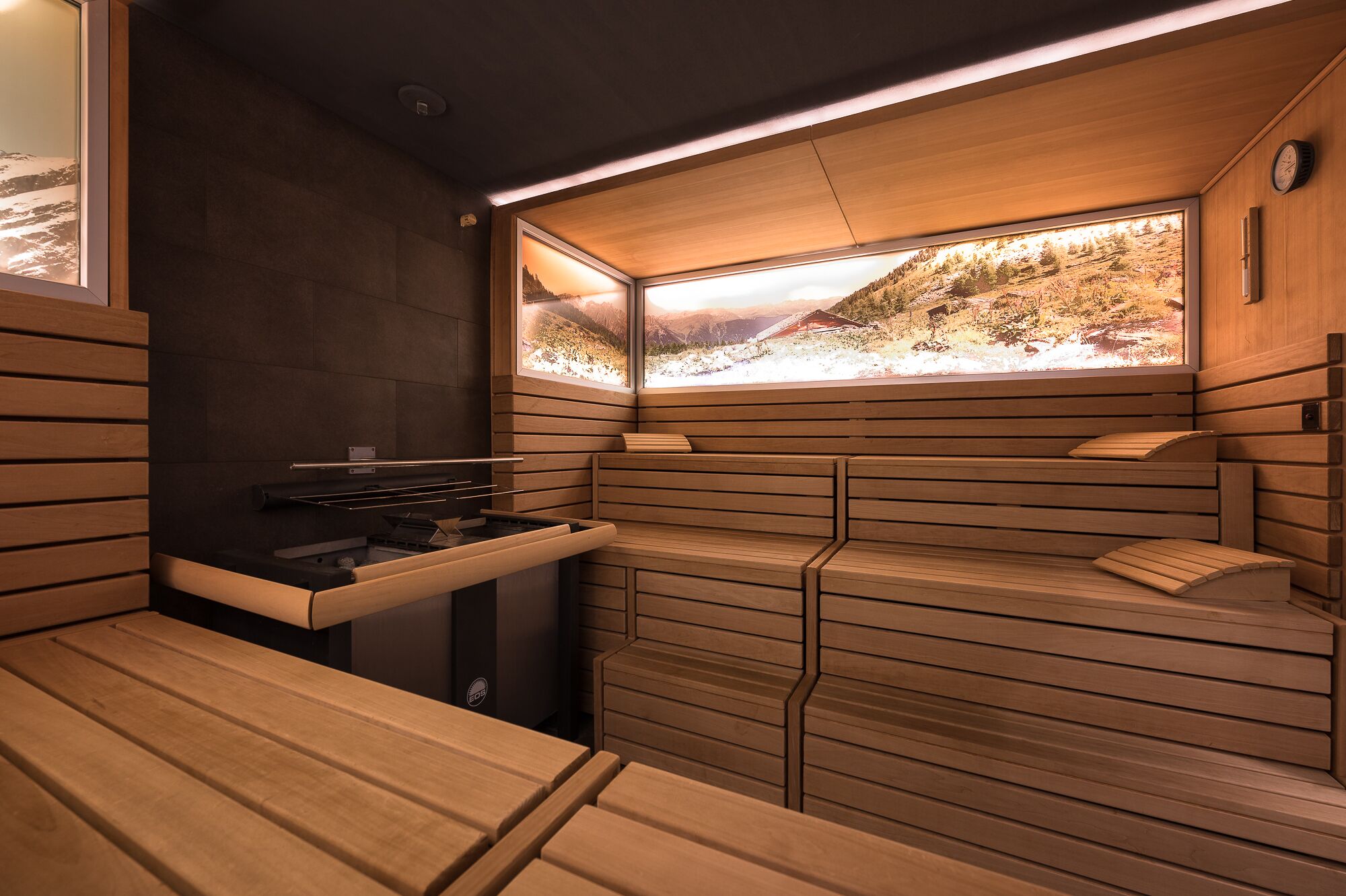 A sauna room with wooden benches and a large window with a scenic view.