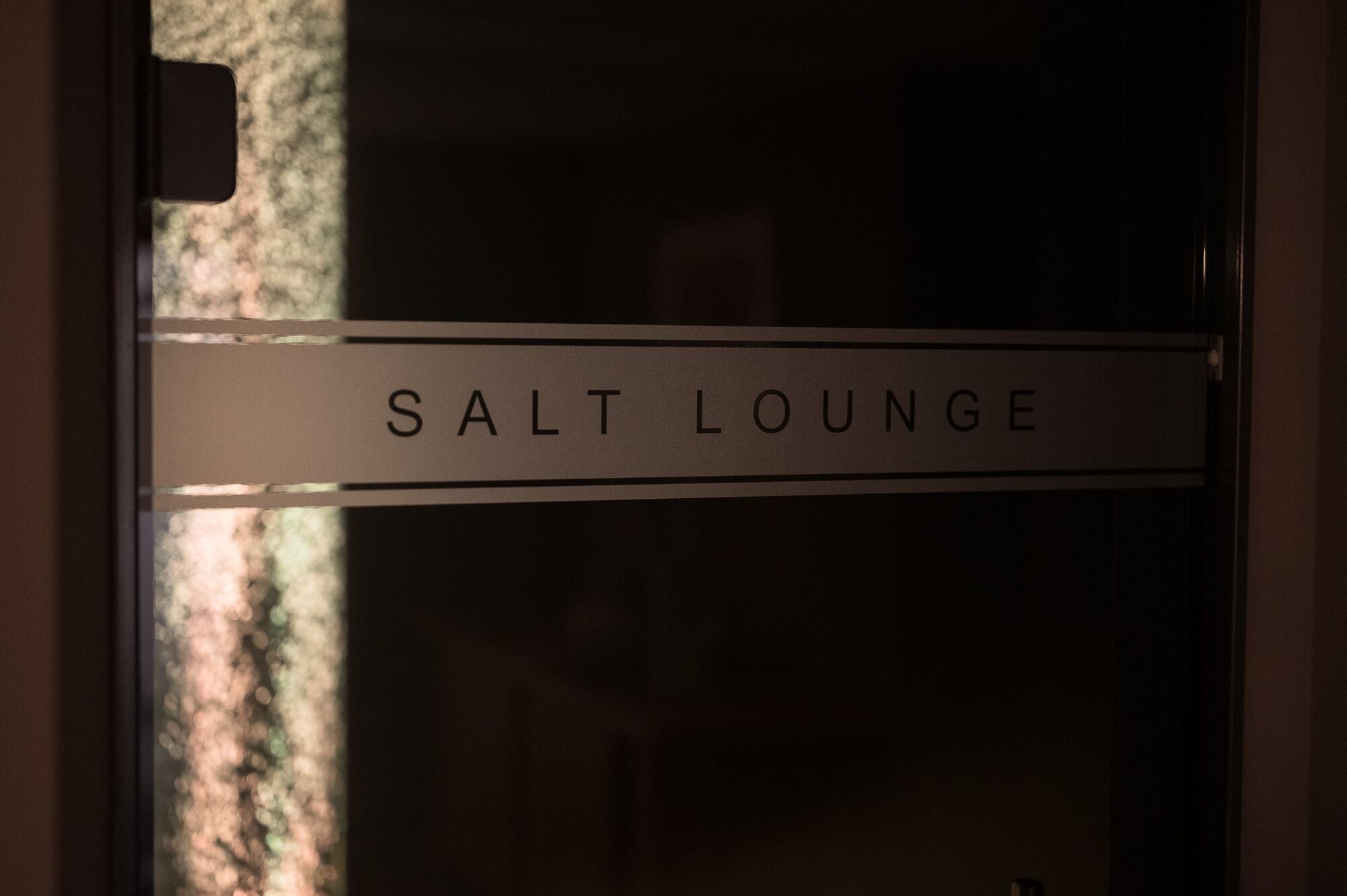 Et skilt på en dør med teksten 'SALT LOUNGE'.