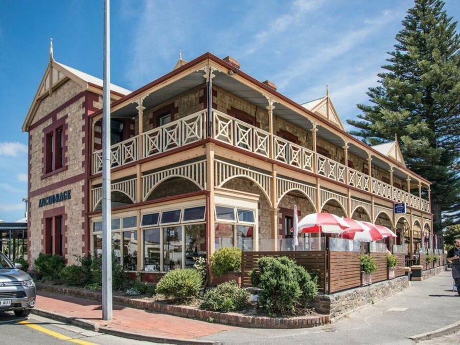 A two-story building with a balcony, arched windows, and a sign reading "ANCHOR RACK".