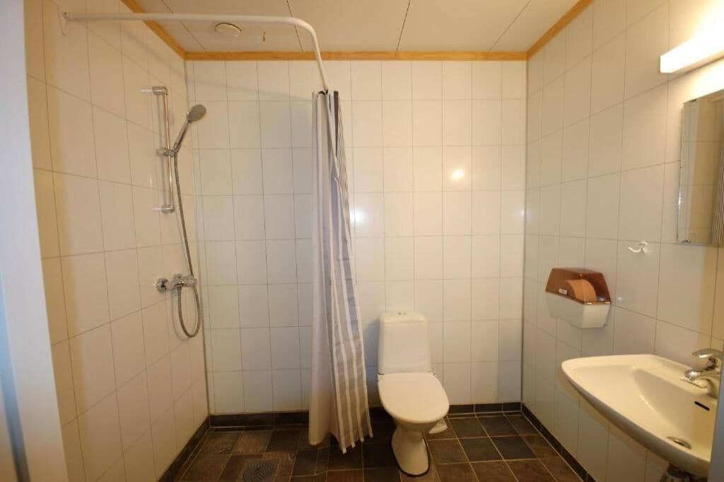 Een compacte badkamer met douche, toilet en wastafel.