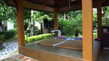 Relax in a serene outdoor space surrounded by lush greenery and comfortable seating.