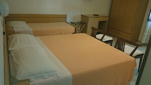Una habitación con dos camas, un escritorio y un armario.