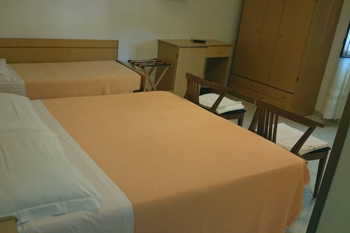 A room with two beds, a desk, and a wardrobe.