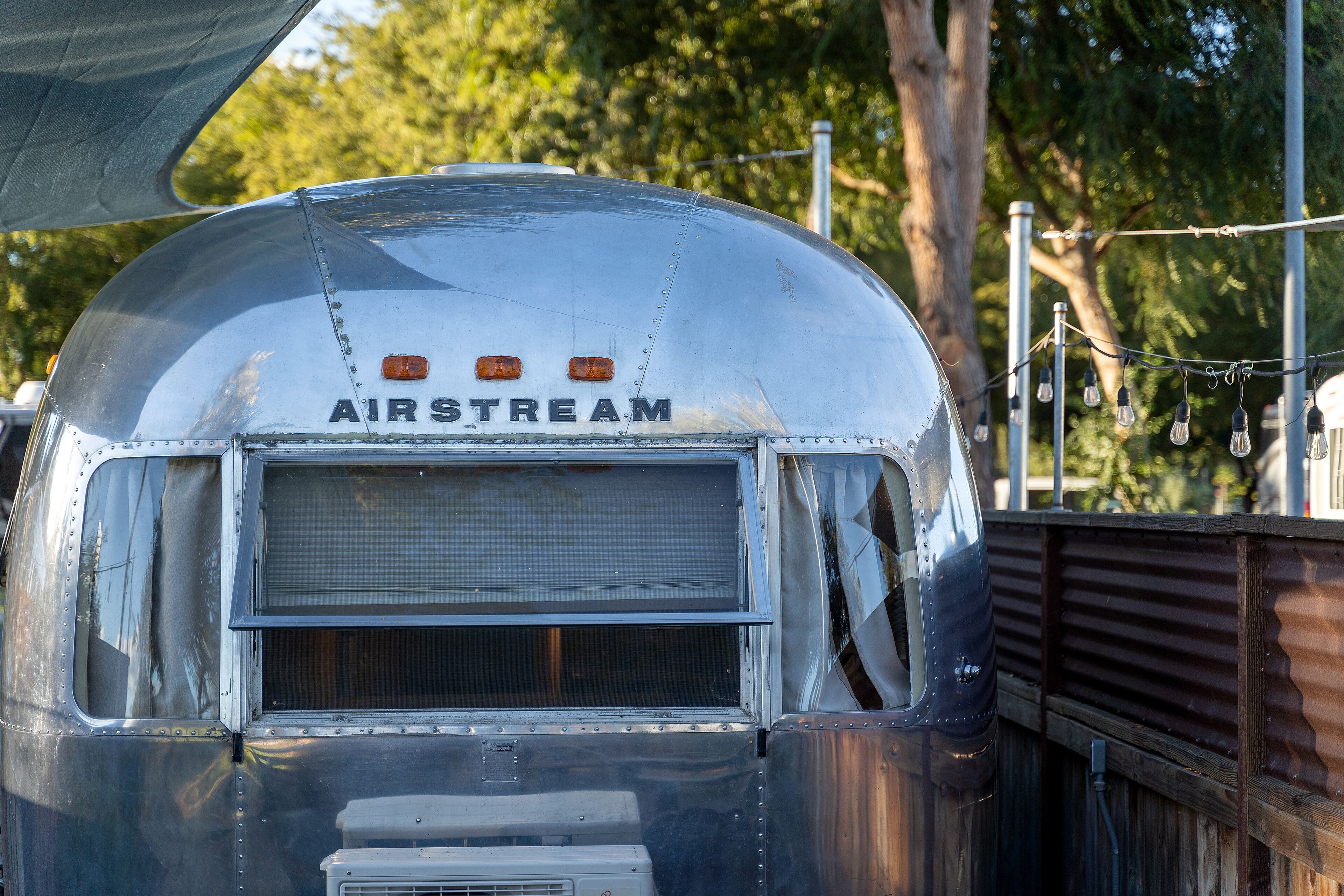 Een klassieke AIRSTREAM caravan met gesloten achterruit en zichtbare airconditioning.