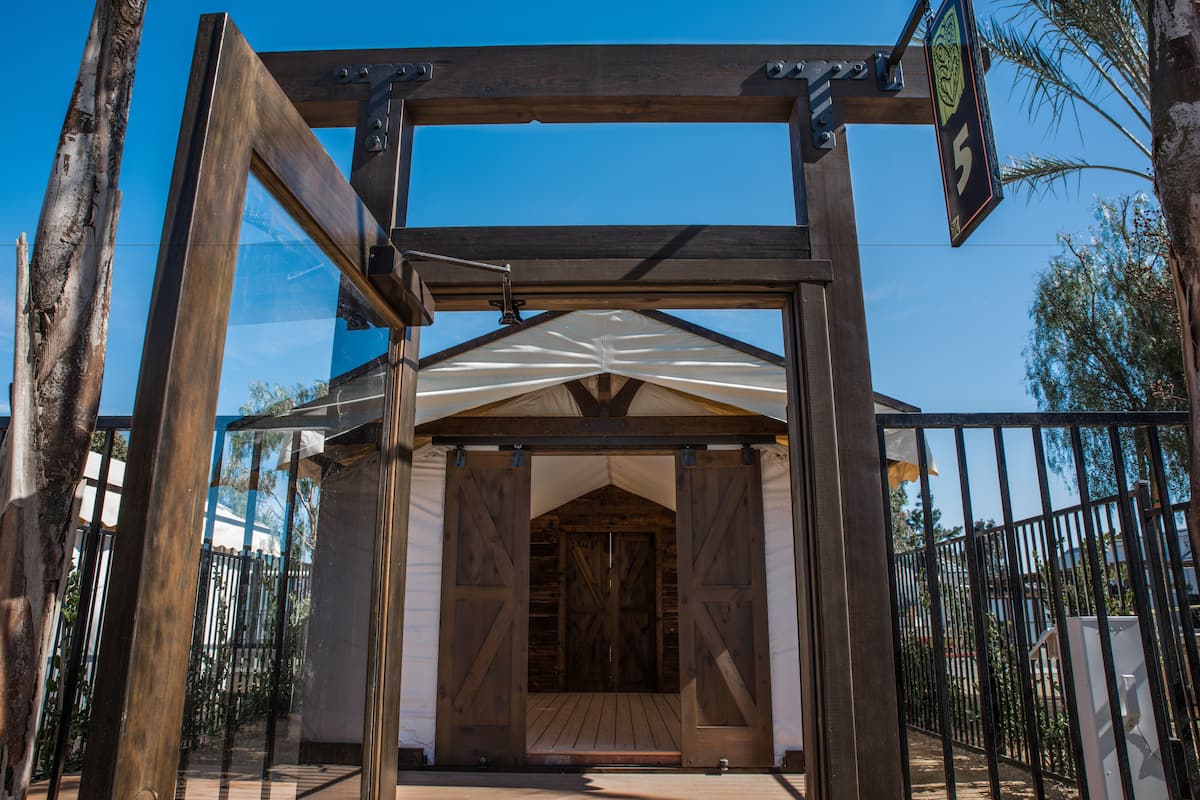 A wooden structure with a large door, a sign with the number 5, and a metal gate.