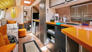 A modern kitchen with a built-in oven, a coffee maker, and a sink.
