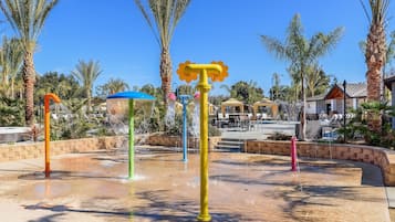 A water park with multiple colorful water features and palm trees.