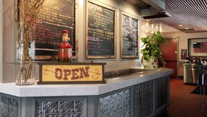 Mostrador de restaurante con un panel de menú que muestra varios platos y un letrero que indica que el establecimiento está abierto.