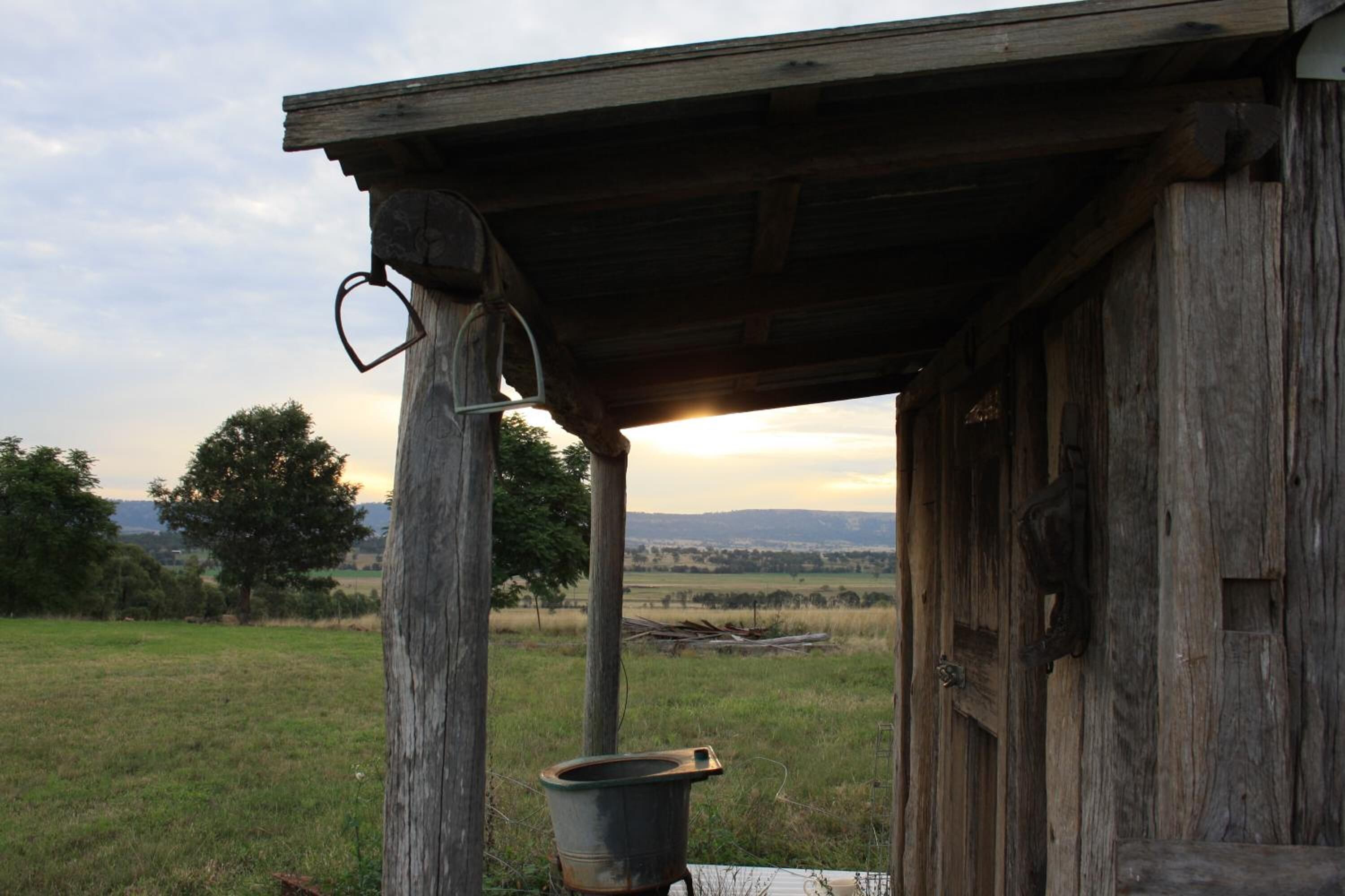 A rustic wooden structure with a metal heart-shaped ornament hanging from a post.