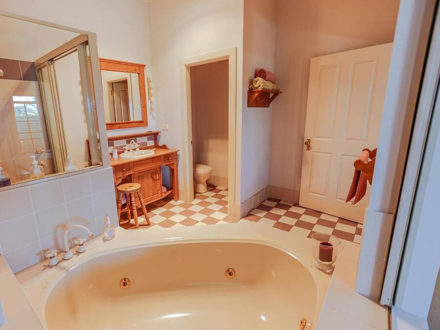 Un baño con bañera, lavamanos, espejo y retrete.