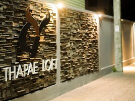 A wall with a textured pattern and the text "THAPAE IOT" in white letters.