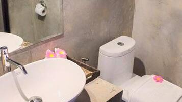 A bathroom with a white sink, a toilet, and a mirror.