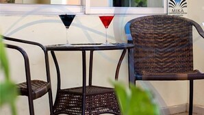 A wicker chair and a small table with a glass. - Mika Convention Center Meanwood (Lusaka)
