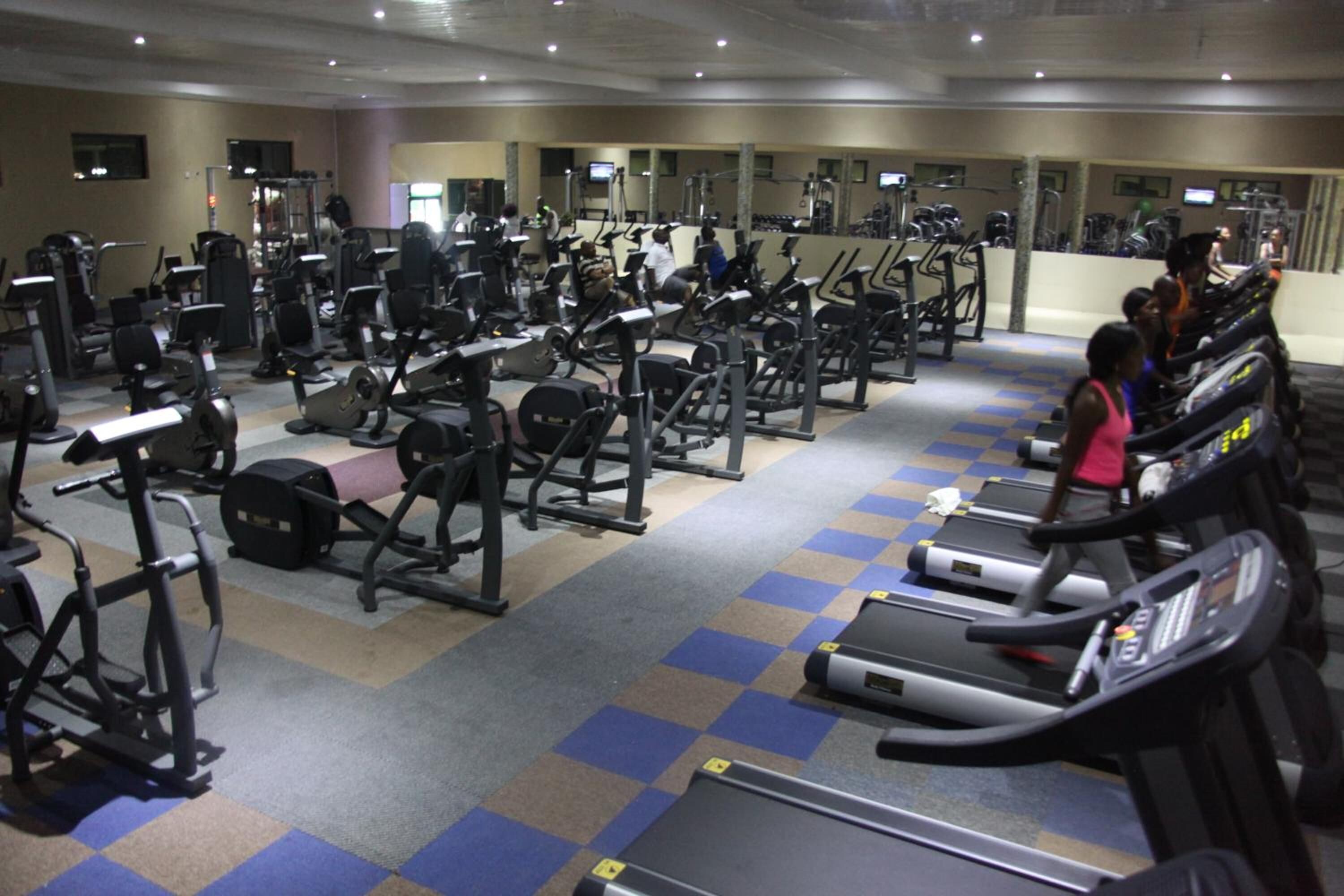 A gym with various exercise equipment, including treadmills and weight machines.