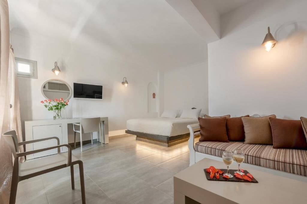 Un dormitorio moderno con cama, mesita de noche y un pequeño escritorio con silla.