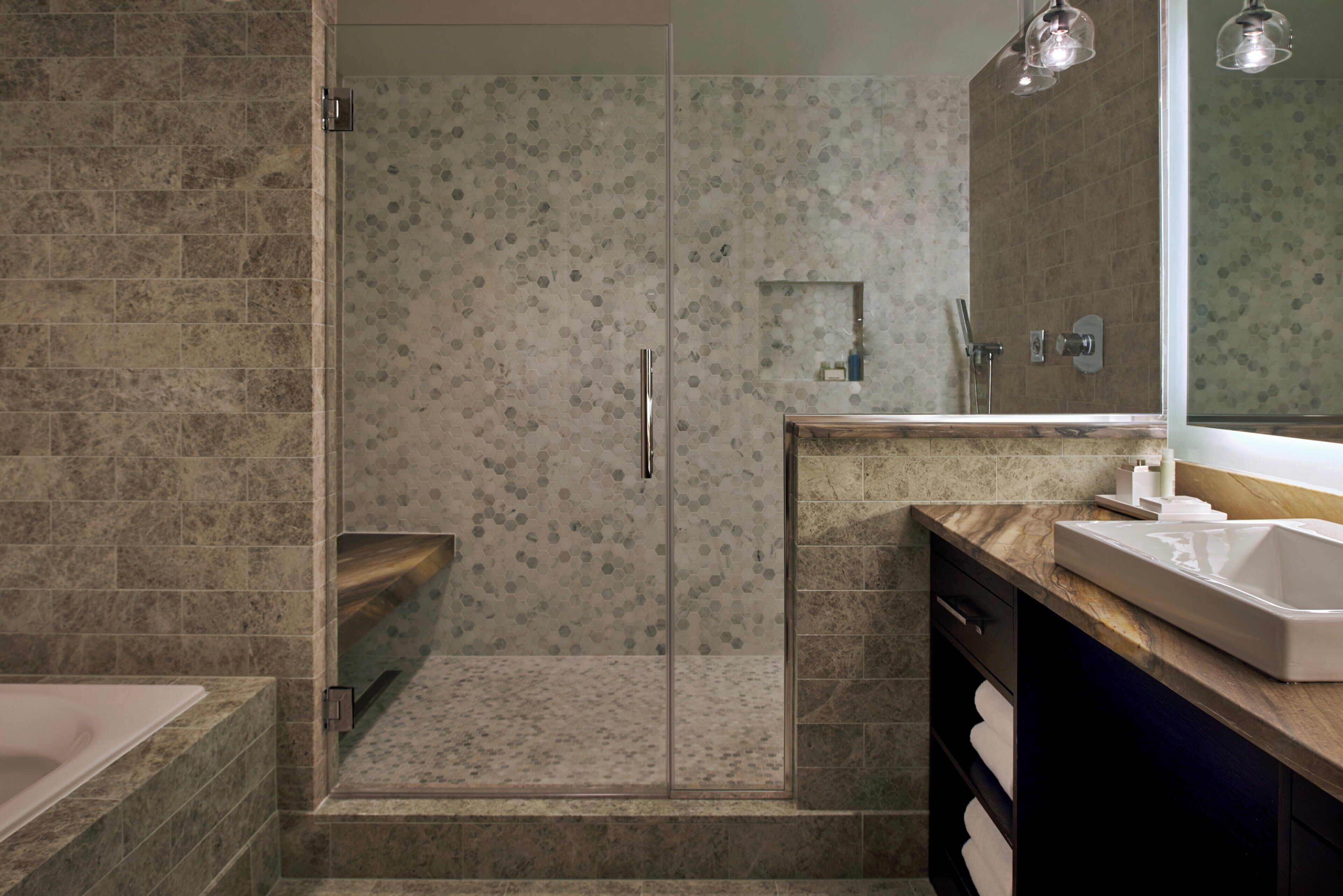 A modern bathroom with a shower, a bathtub, and a vanity with a sink.