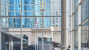 A modern hotel lobby with large windows, a flag, and a coffee station.