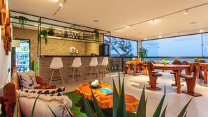 Un intérieur moderne avec un bar-cuisine, un coin salon et de grandes fenêtres donnant sur la mer.