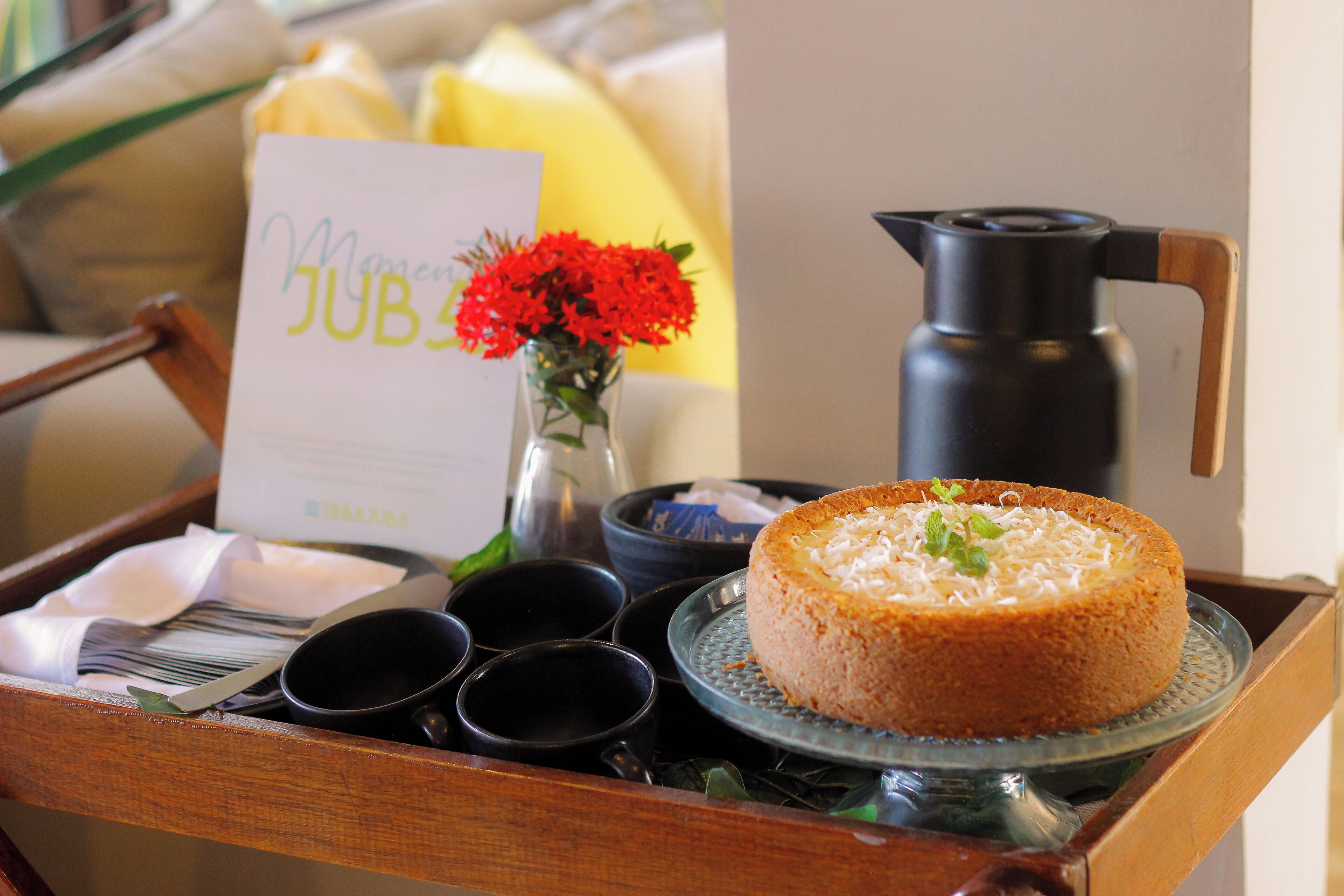 A tray with a cake, a coffee pot, and a menu.