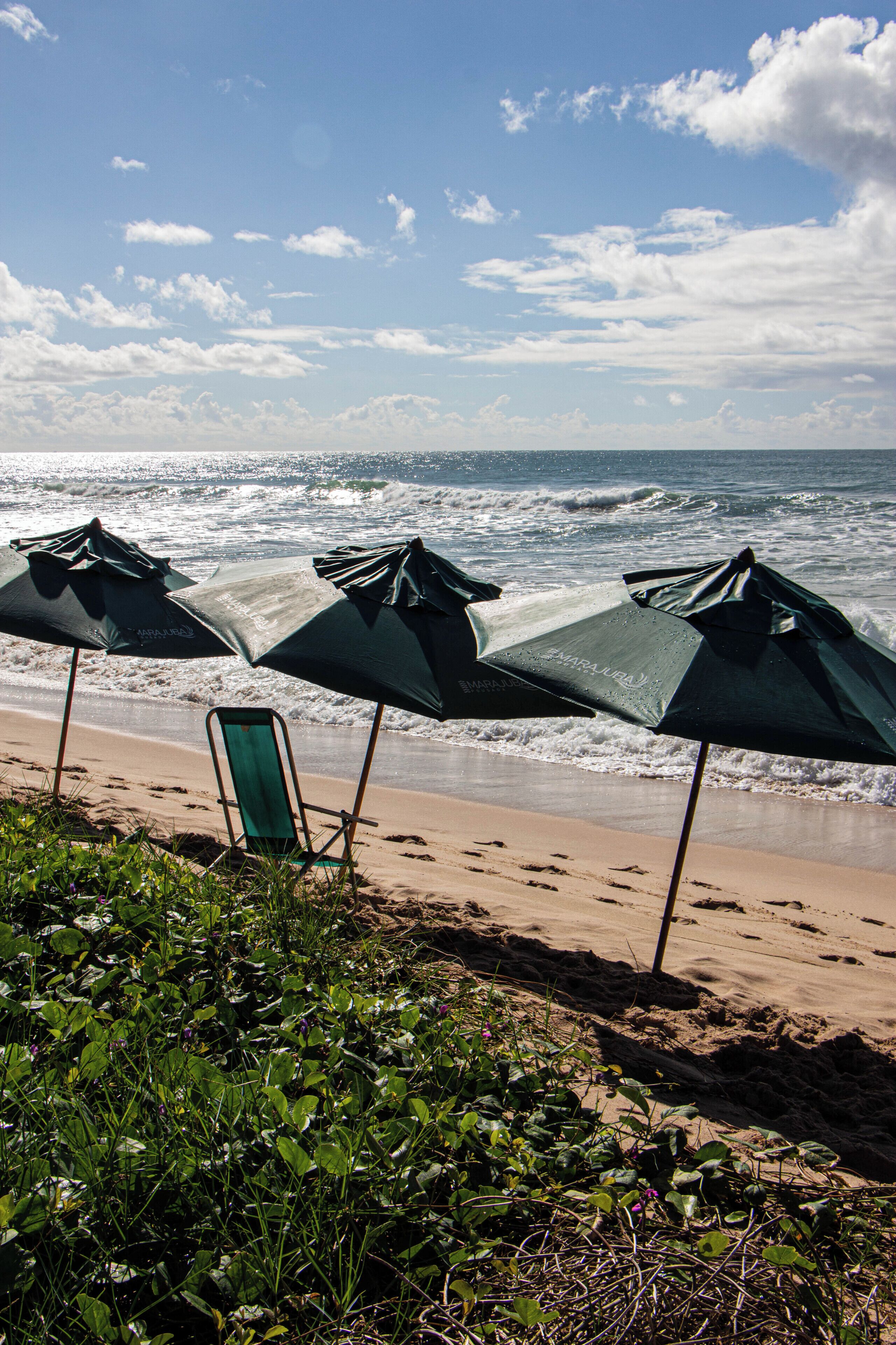 Beach umbrellas, a chair, and ocean waves.