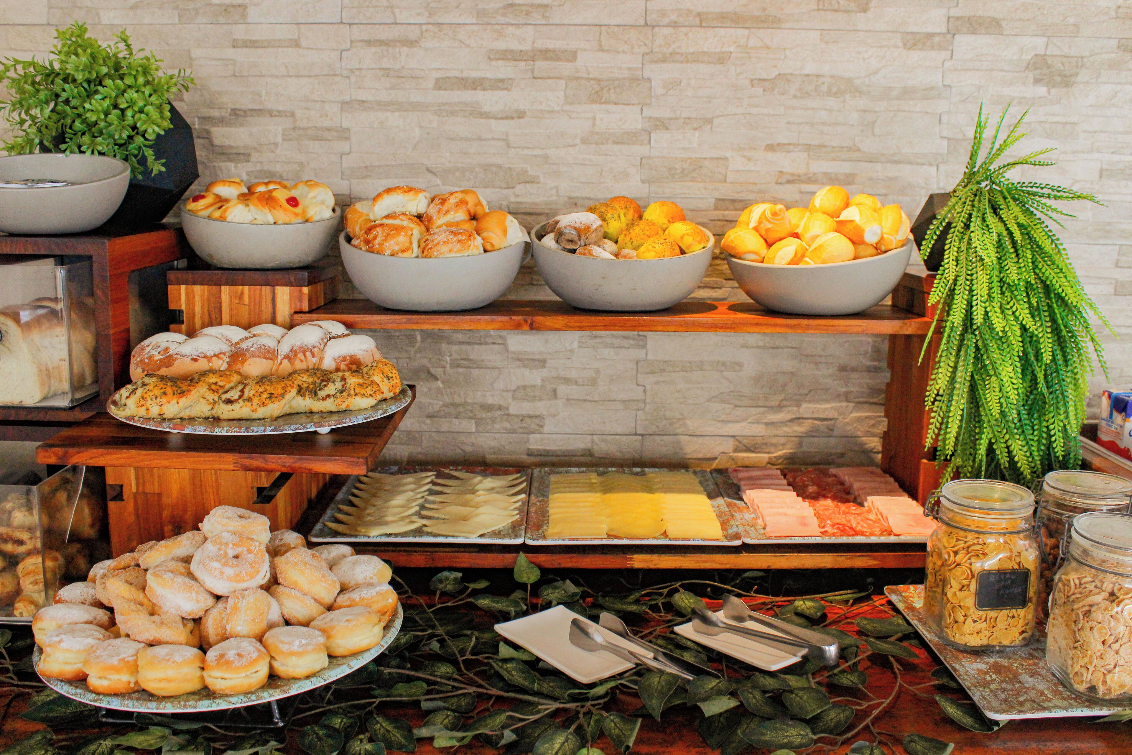 Un buffet proposant une variété de plats, notamment des pâtisseries, des fruits et des fromages.