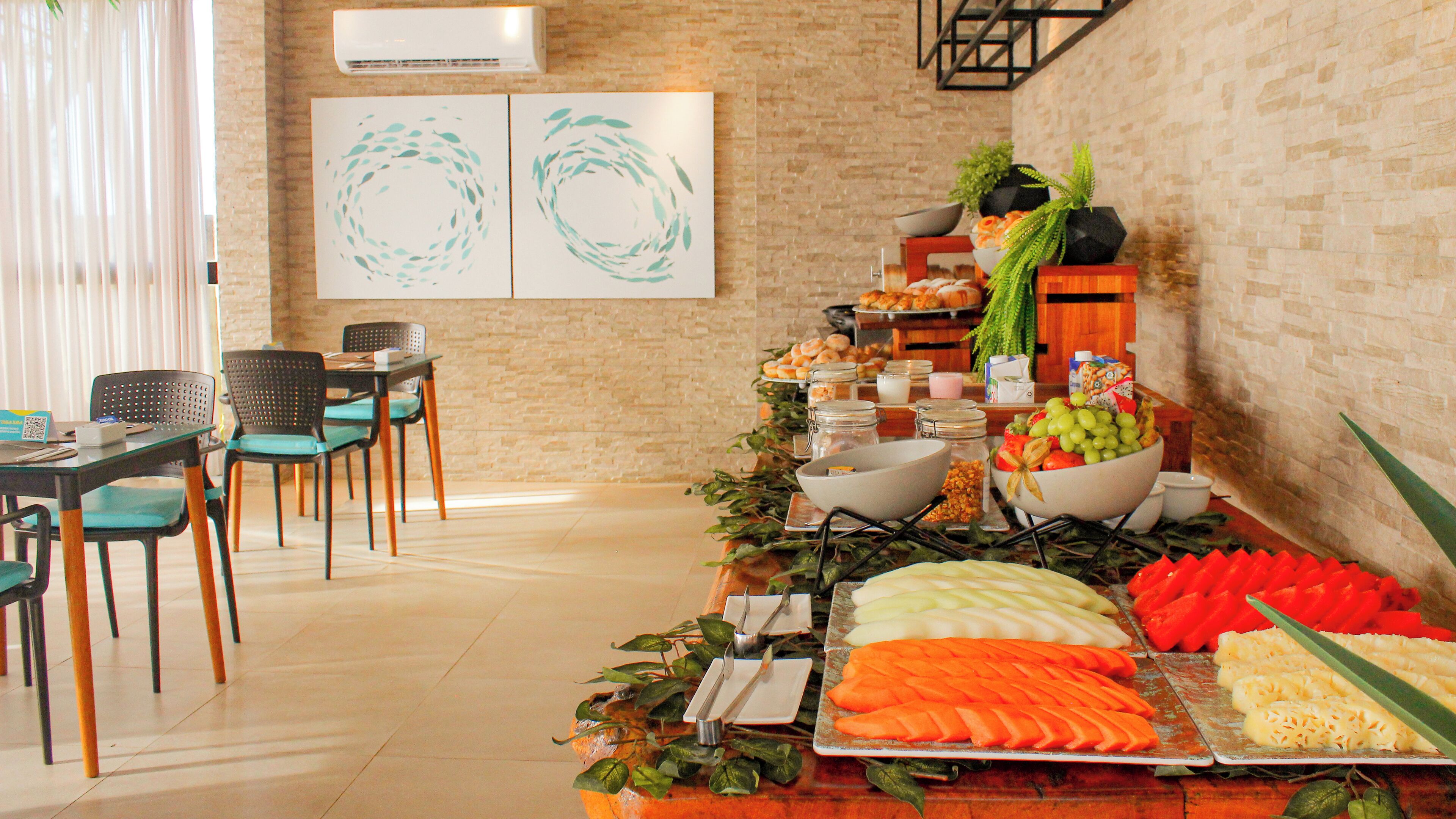 A buffet setup with various food items and a seating area with chairs and a table.