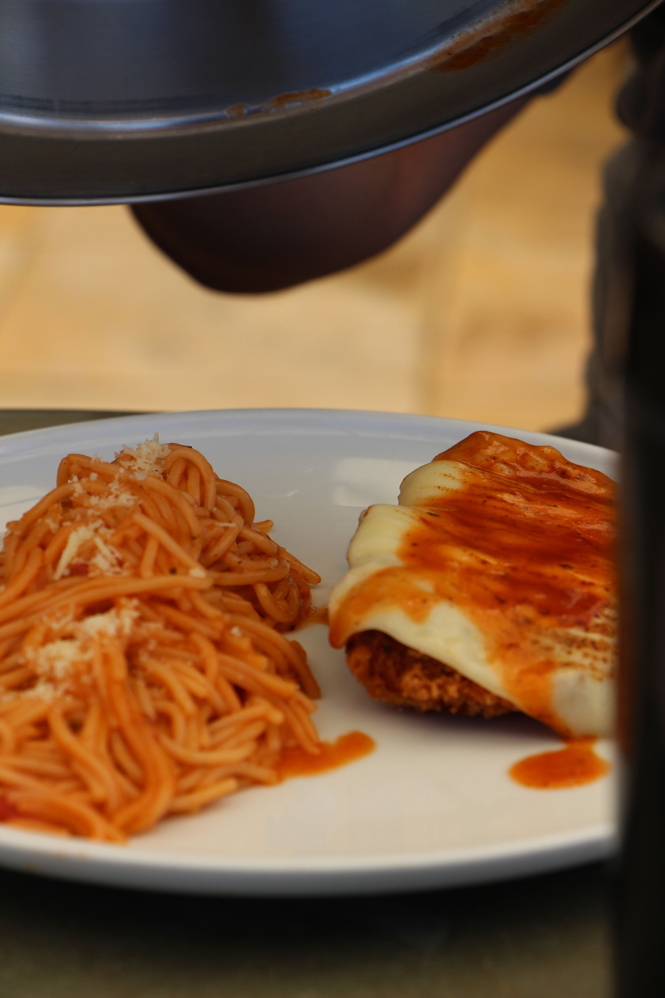 Een bord spaghetti en een stuk pizza.