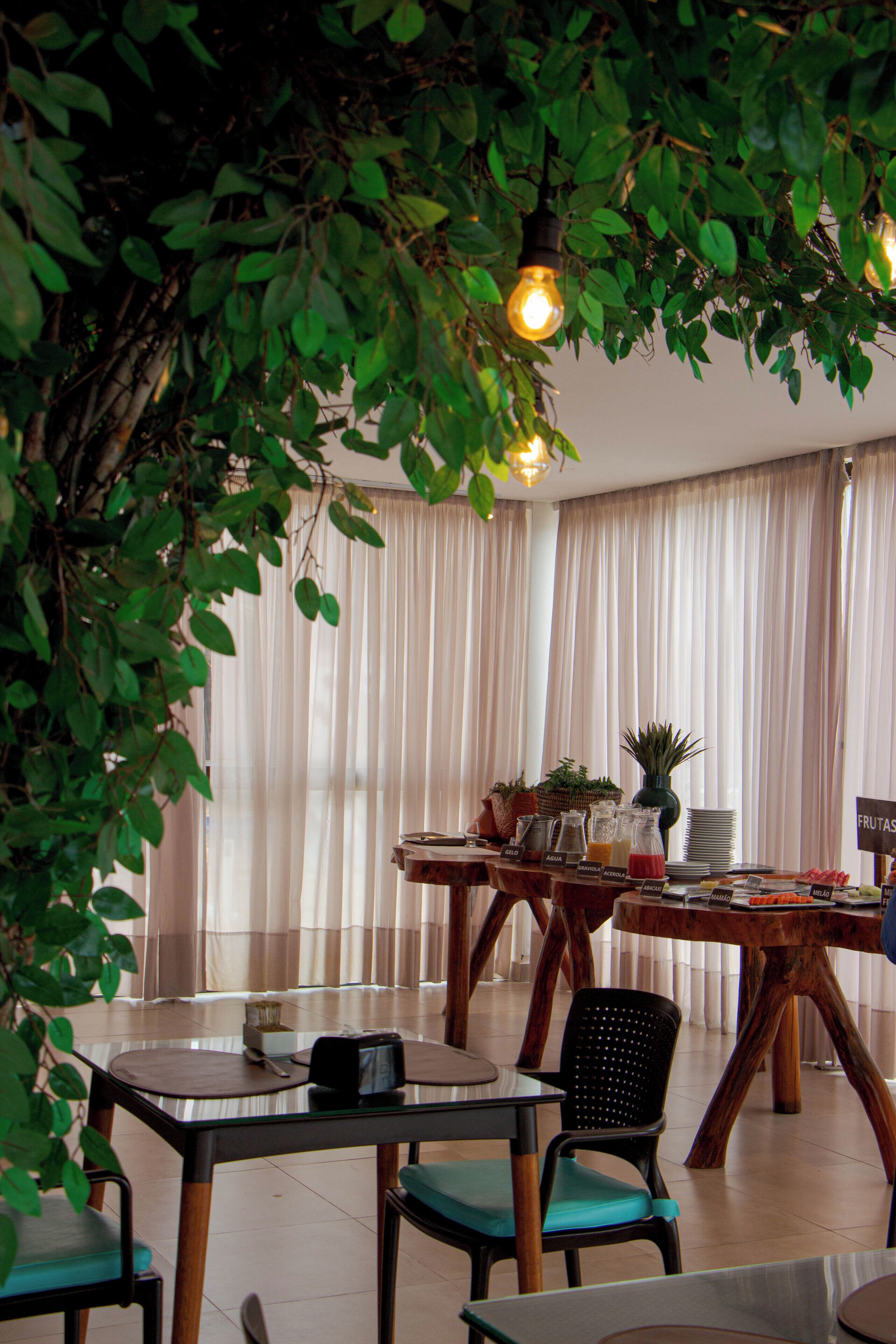 A dining area with a table, chairs, and a hanging light fixture.