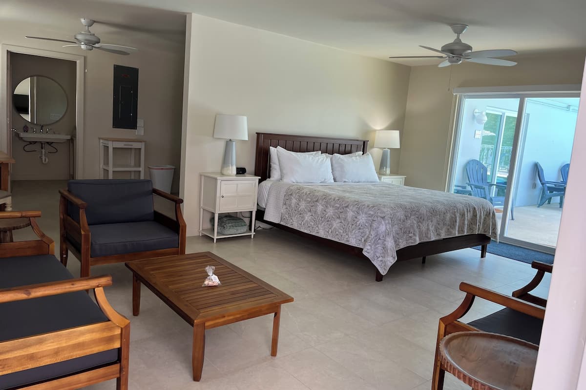 A bedroom with a bed, bedside tables, a nightstand, a wooden coffee table, and a chair.