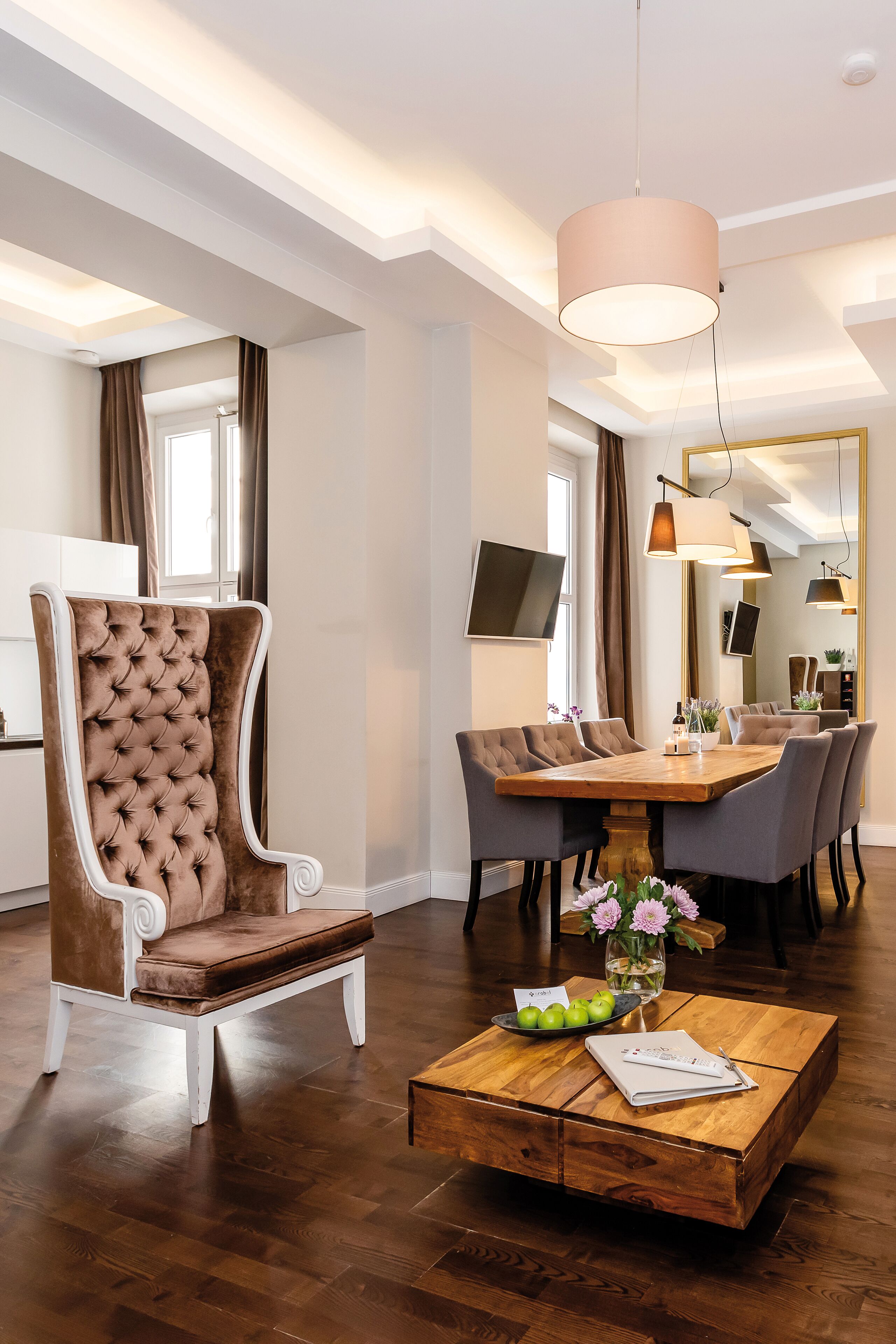 Un espace repas moderne avec une table en bois, des chaises rembourrées et un fauteuil capitonné.