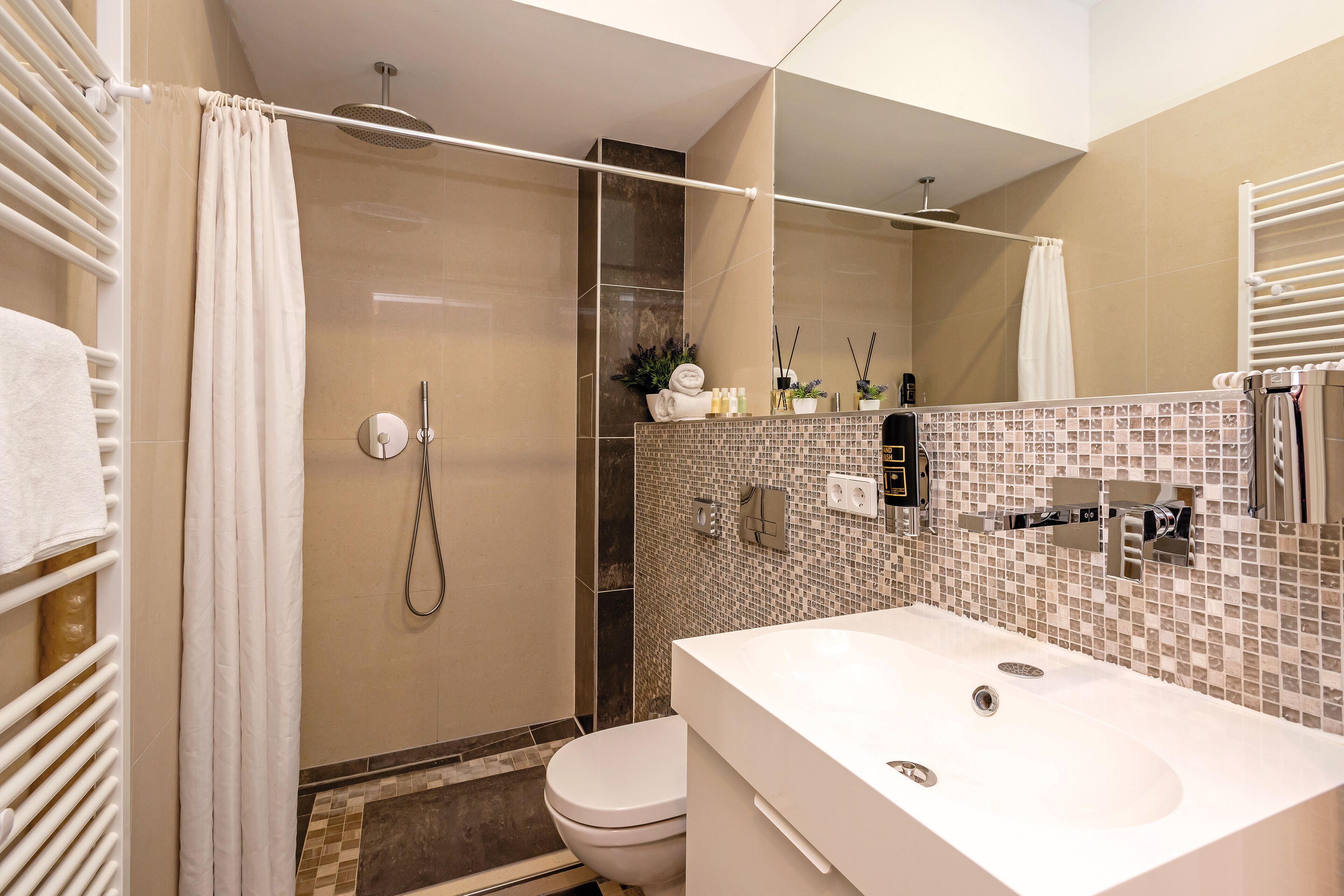 Un baño moderno con ducha, inodoro y lavamanos.