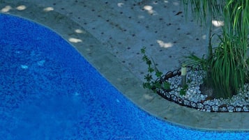 Una piscina al aire libre, tumbonas