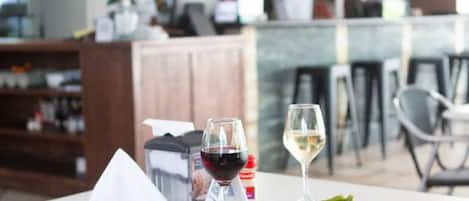 Une table dressée avec un repas, des verres à vin et un menu.