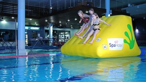 En indendørs swimmingpool med vandrutsjebaner.