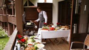En buffet med forskellige retter og en kok, der tilbereder mad.