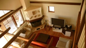 En stue i loftstil med pejs, fjernsyn og hyggelig siddeplads.