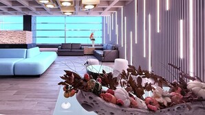 Un interior moderno con un sofá modular, una mesa de centro con plantas decorativas y un techo con estampado.